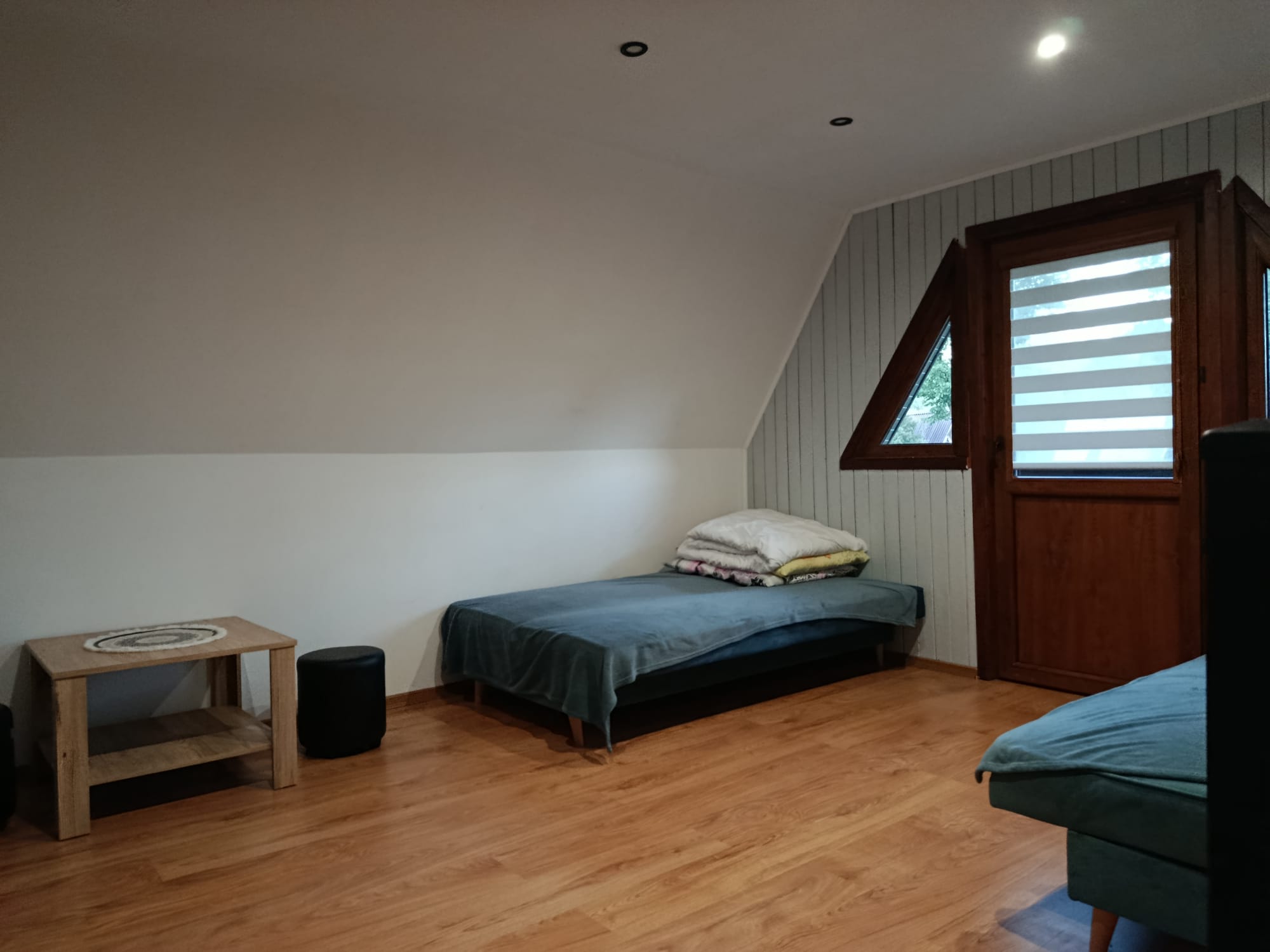 Pokój z dwoma łóżkami i małym stolikiem, utrzymany w jasnych, naturalnych barwach.